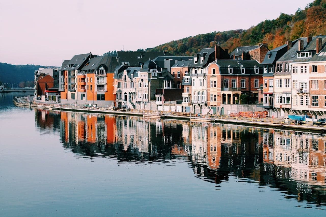 Dinant waterfront along the Meuse river — Belgian architecture reflecting layered governance and accountability